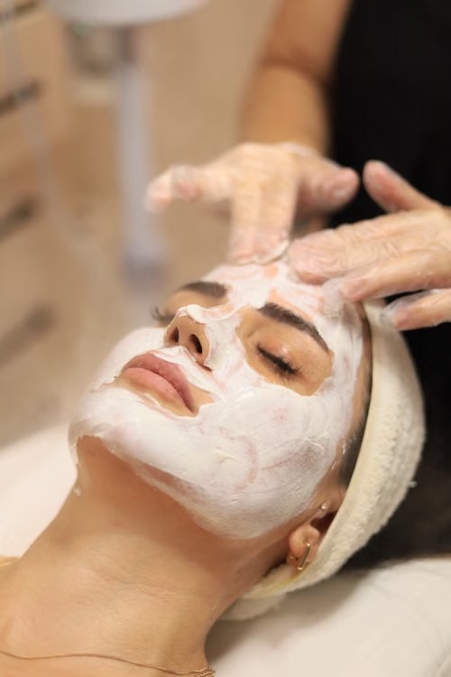 Studente krijgt een gezichtsbehandeling met een verzorgend masker bij Sade Skin in Antwerpen